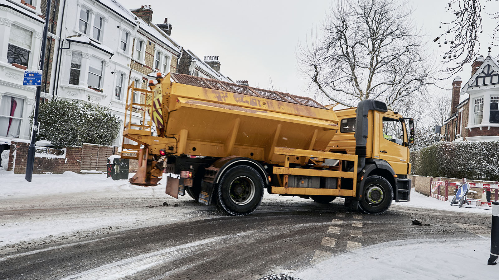 Salt and ice melting truck treating icy pavement